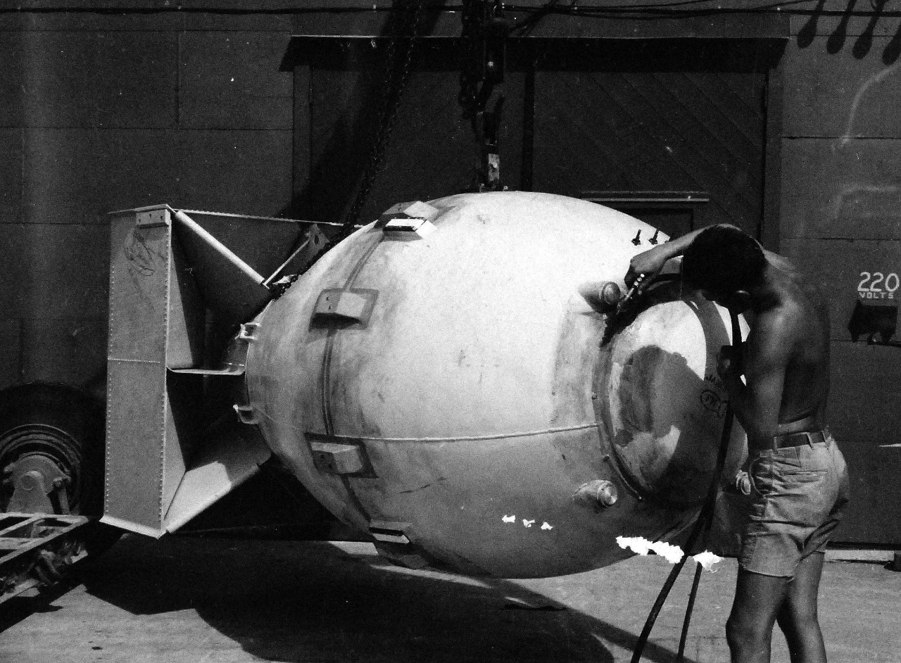 77-BT-185:   Tinian Island, August 1945.   Polar cap of atomic bomb, Fat Man, being sprayed with platic paint before assembly in building #2.   Official photograph of the Office of Chief of Engineers, now in the collection of the National Achives.   (2015/08/25). 