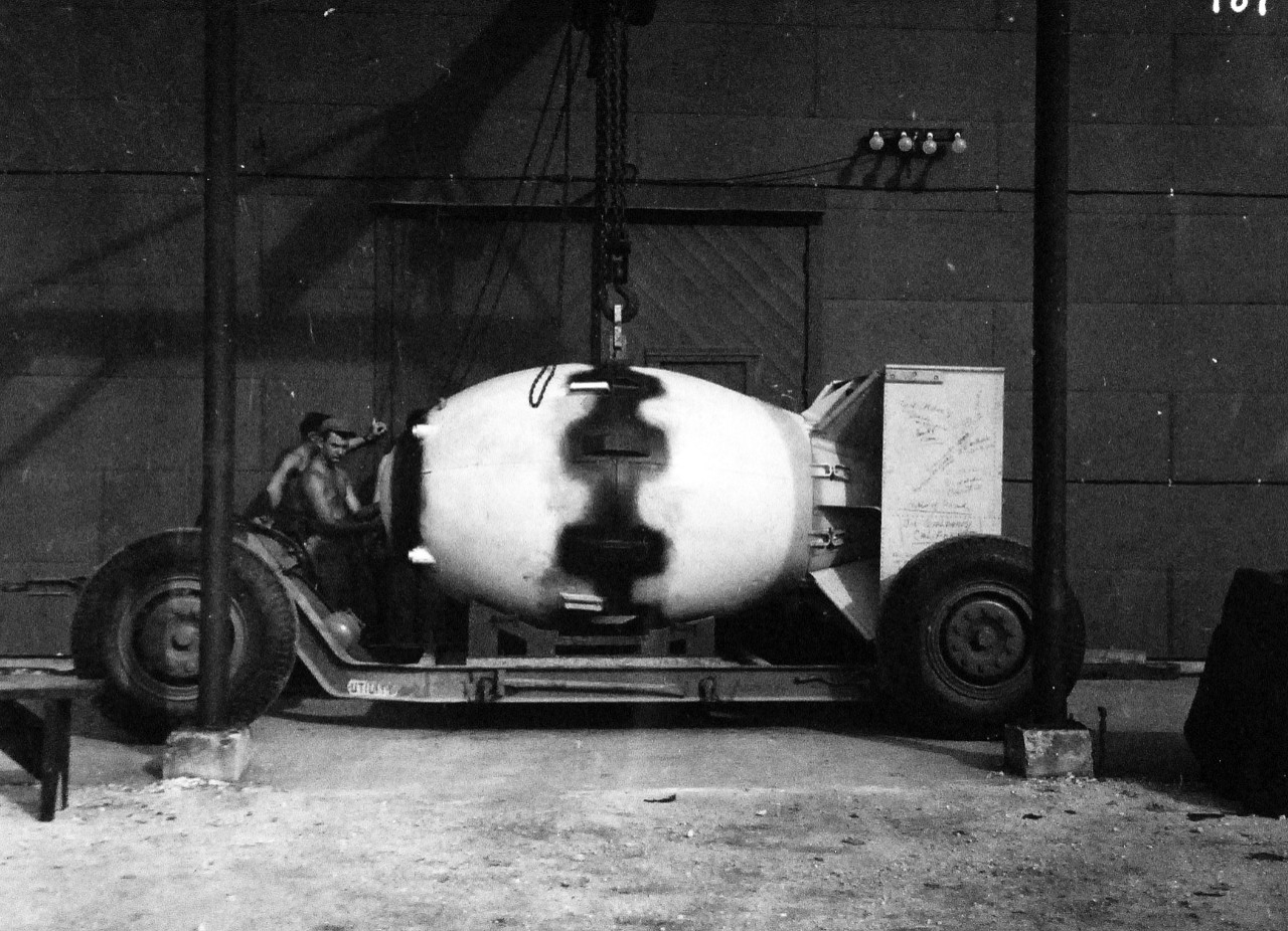 77-BT-187:   Tinian Island, August 1945.    Atomic Bomb, Fat Man, being placed on trailer cradle in front of assembly building #2.  Official photograph of the Office of Chief of Engineers, now in the collection of the National Achives.   (2015/08/25). 
