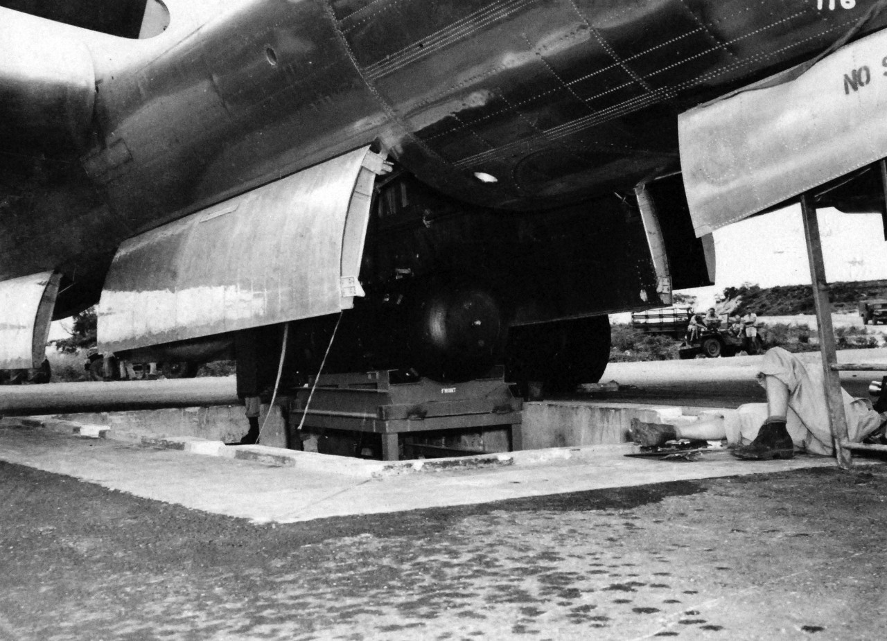 77-BT-116:   Tinian Island, August 1945.   Atomic bomb, Little Boy, on trailer cradle being hoisted into bomb bay of Boeing B-29 Superfortress, Enola Gay.   Official photograph of the Office of Chief of Engineers, now in the collection of the National Achives.   (2015/08/25). 