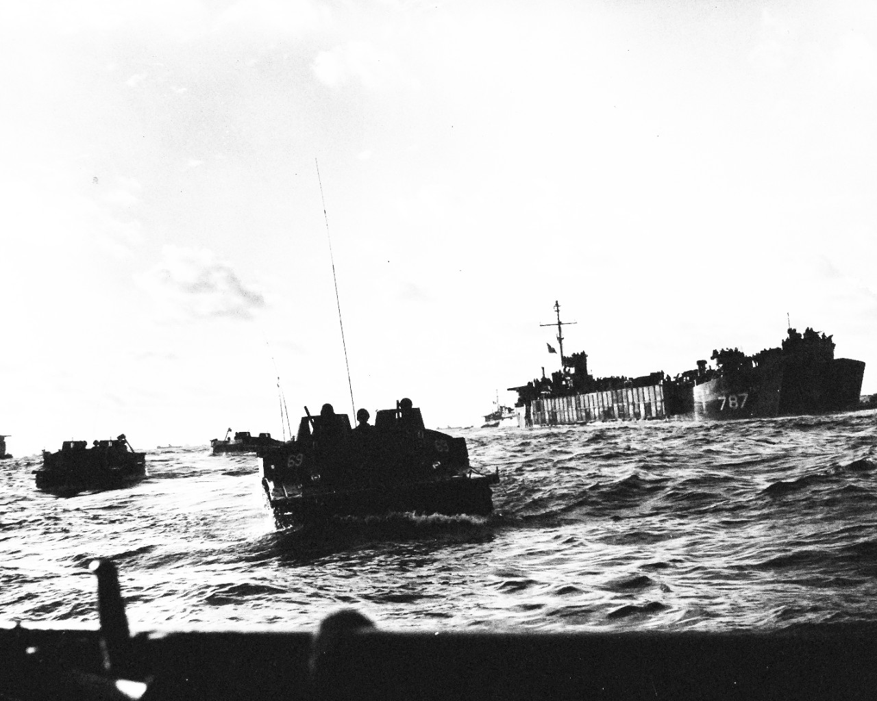 80-G-304871:  Battle for Iwo Jima, February 19, 1945.   Off the fire-swept beaches of Iwo Jima, Amtracks loaded with Marines emerge from the depths of a Coast-Guard manned LST-787 at the right and surge toward shore on D-Day.  Official U.S. Navy Photograph now in the collections of the National Archives.  (2016/01/19).