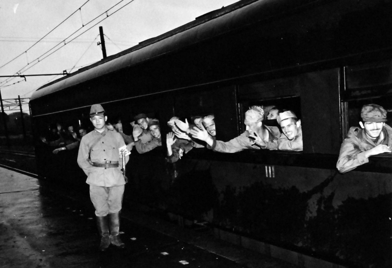 80-G-339425:  Prisoner of War Camp, Ofuna, Yokohama, Japan, 1945.   Liberated American Prisoners of War leave Ofuna prison camp by train bound for Atsugi, September 1, 1945.   Ofuna was located at Kamakura, Japan, just outside of Yokohama.   Photographed by Photographer’s Mate Cates.    Official U.S. Navy photograph, now in the collection of the National Archives.  (2013/08/14).    Note, the original photograph is about 1” x 1” in size.   