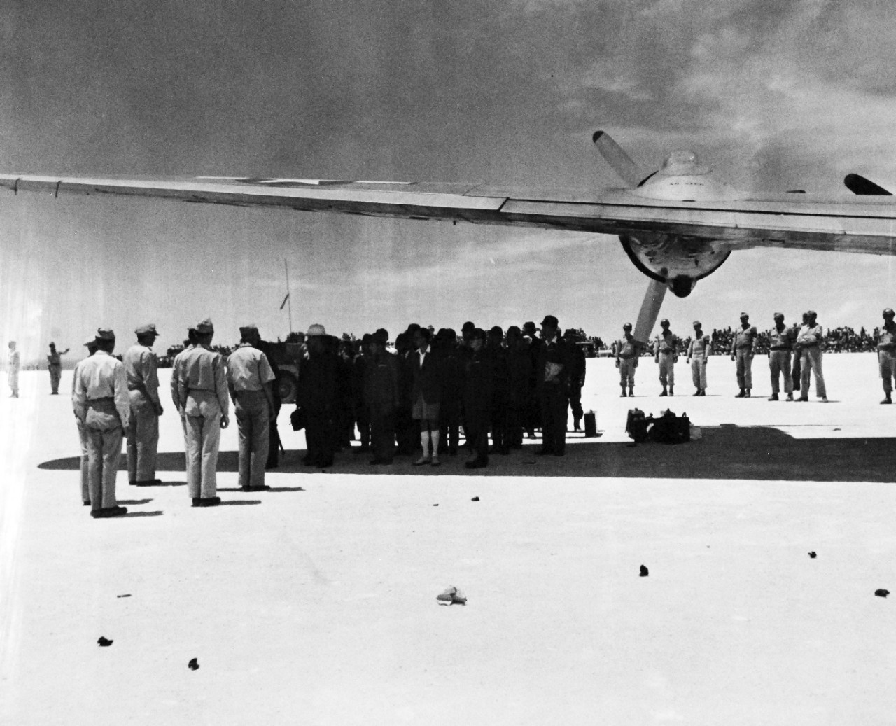 80-G-490358:  Surrender of Japan, August-September 1945.  High ranking officers of the U.S. Army face Japanese envoys to General Douglas A. MacArthur, under the wing of a giant C-54 waiting on Ie Shima to take the enemy dignitaries to Manila for conferences with the Allied Commander-in-Chief.  The Japanese landed at the island in distinctly marked planes (Red Crosses) and transferred to the transport for the last leg of their journey.  Photograph released August 19, 1945.  Official U.S. Navy Photograph, now in the collections of the National Archives.  (2015/11/10).