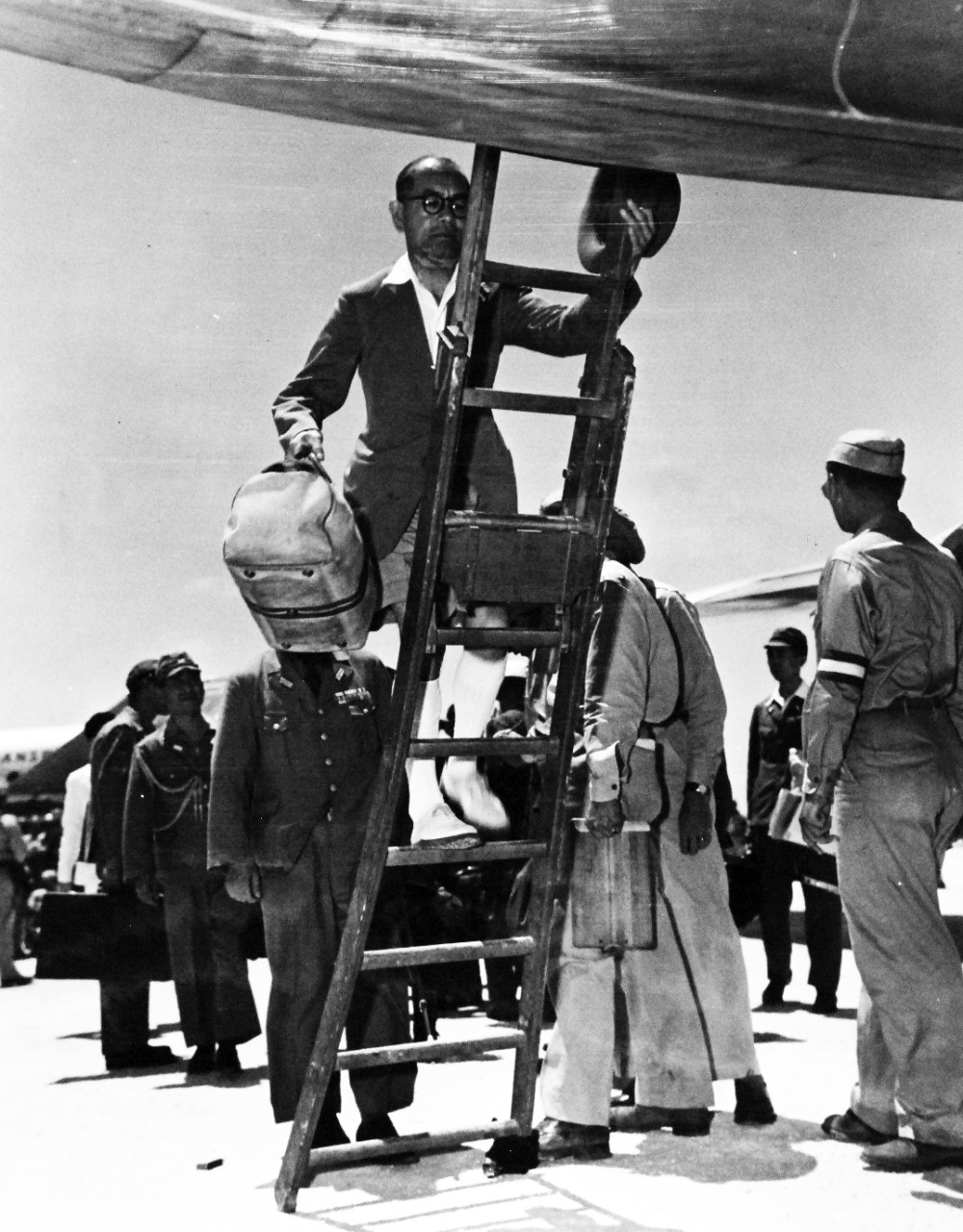 80-G-490360:  Surrender of Japan, August-September 1945.  Japanese envoys mounting the ladder of a C-54 at Ie Shima.  The plane will take them on the last step of their journey to Manila for a conference with General Douglas MacArthur.  Photograph released August 19, 1945.  Official U.S. Navy Photograph, now in the collections of the National Archives.  (2015/11/10).