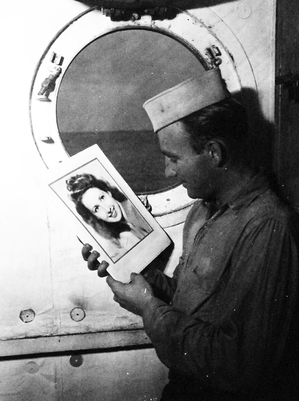80-G-354678:  V-J Day, August 15, 1945.    Richard Chaldu S1/C aboard USS Ticonderoga (CV-14) kissed the picture of his wife when he heard the news of V-J Day.   Photographed by PhoM3/c J.D. McGhie.    Photographed August 15, 1945.  Official U.S. Navy photograph, now in the collections of the National Archives.  (2016/06/21).