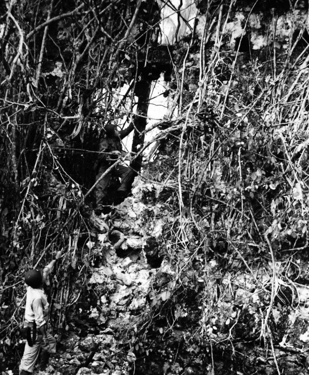 26-G-3570-Box 70-1:  Invasion of Leyte, Philippines, 20 October 1944.  The Exterminators Probe Leyte’s Jungles.  In Cliffside caves, curtained by the tangled jungle vines and creepers, Japanese snipers ply their deadly business of picking-off American soldiers and Coast Guardsmen occupying Leyte Island.  Here, two Yankees cautiously inch their way toward a pocket from which they suspect death had been spouting.   They were the exterminators, mopping up the Japanese that shoot from sniper nests.  Official U.S. Coast Guard photograph, now in the collections of the National Archives.   (2015/12/15).