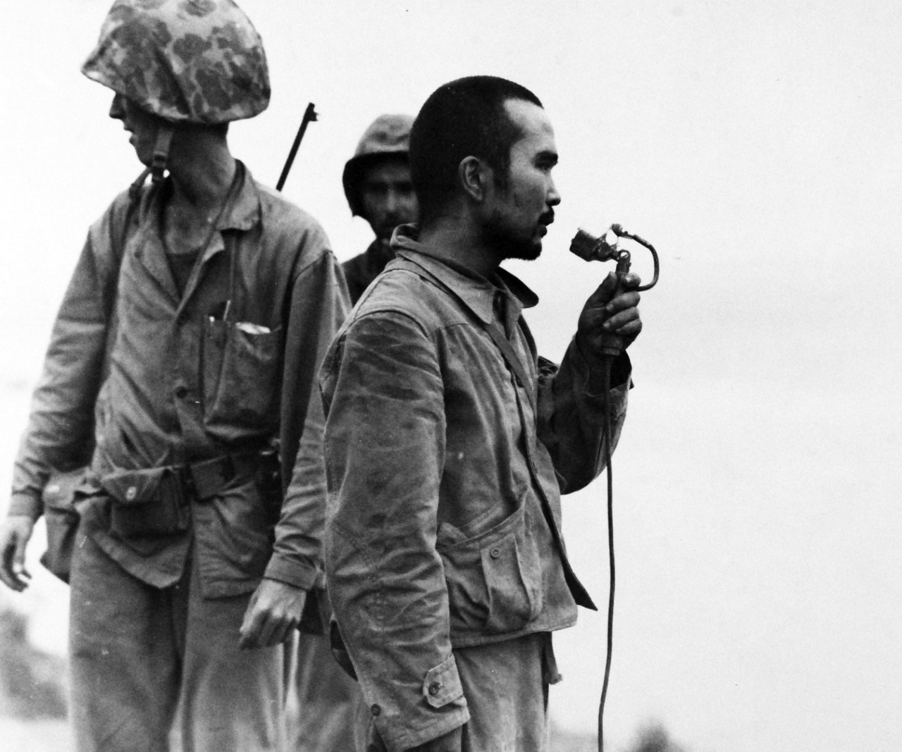 80-G-287247:   Invasion of Saipan, June-July 1944.  Japanese soldiers taken prisoner after being persuaded to come out of caves near Marpi Point on Saipan, Japanese soldier using loud speaker asking his friends to come out, July 12, 1944.  Photographed by USS Indianapolis (CA-35) photographer.   Official U.S. Navy Photograph, now in the collections of the National Archives.  (2017/03/21).  