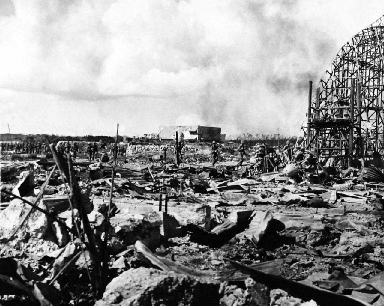 80-G-239297:  Invasion of Tinian, July-August 1944.   U.S. Marines move across the wreckage of a Japanese airfield on the northern end of Tinian Island in the Mariana Islands as they continue their mopping up operations, released  August 4, 1944.    Official U.S. Navy photograph, now in the collections of the National Archives.  (2017/03/07).
