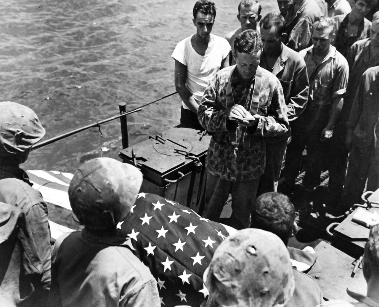80-G-239299:  Invasion of Tinian, July-August 1944.   A U.S. Marine who died in the assault on Tinian Island is given the highest military honor – burial at sea.  Lieutenant Joseph P. F. Gallagher, USNR, Catholic Chaplain attached to the Second Marine Division reads the burial prayers, released  August 4, 1944.    Official U.S. Navy photograph, now in the collections of the National Archives.  (2017/03/07).