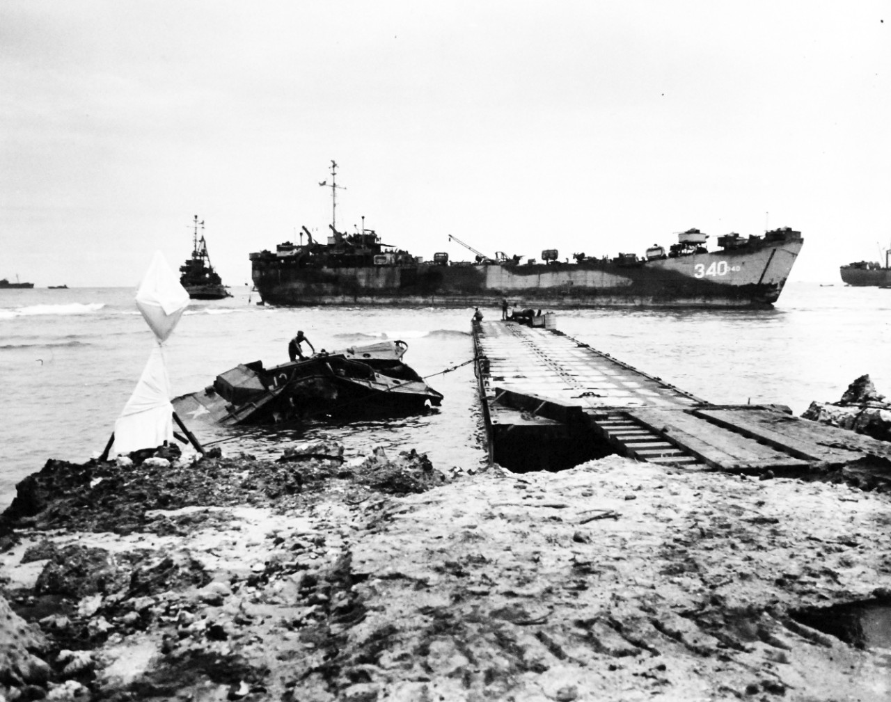80-G-307883:  Invasion of Tinian, July-August 1944.   USS LST-340 at pontoon pier on White Beach 2, TA 639, Tinian Island during invasion. Photograph received March 20, 1945.      Official U.S. Navy photograph, now in the collections of the U.S. Navy.  (2017/04/11).  