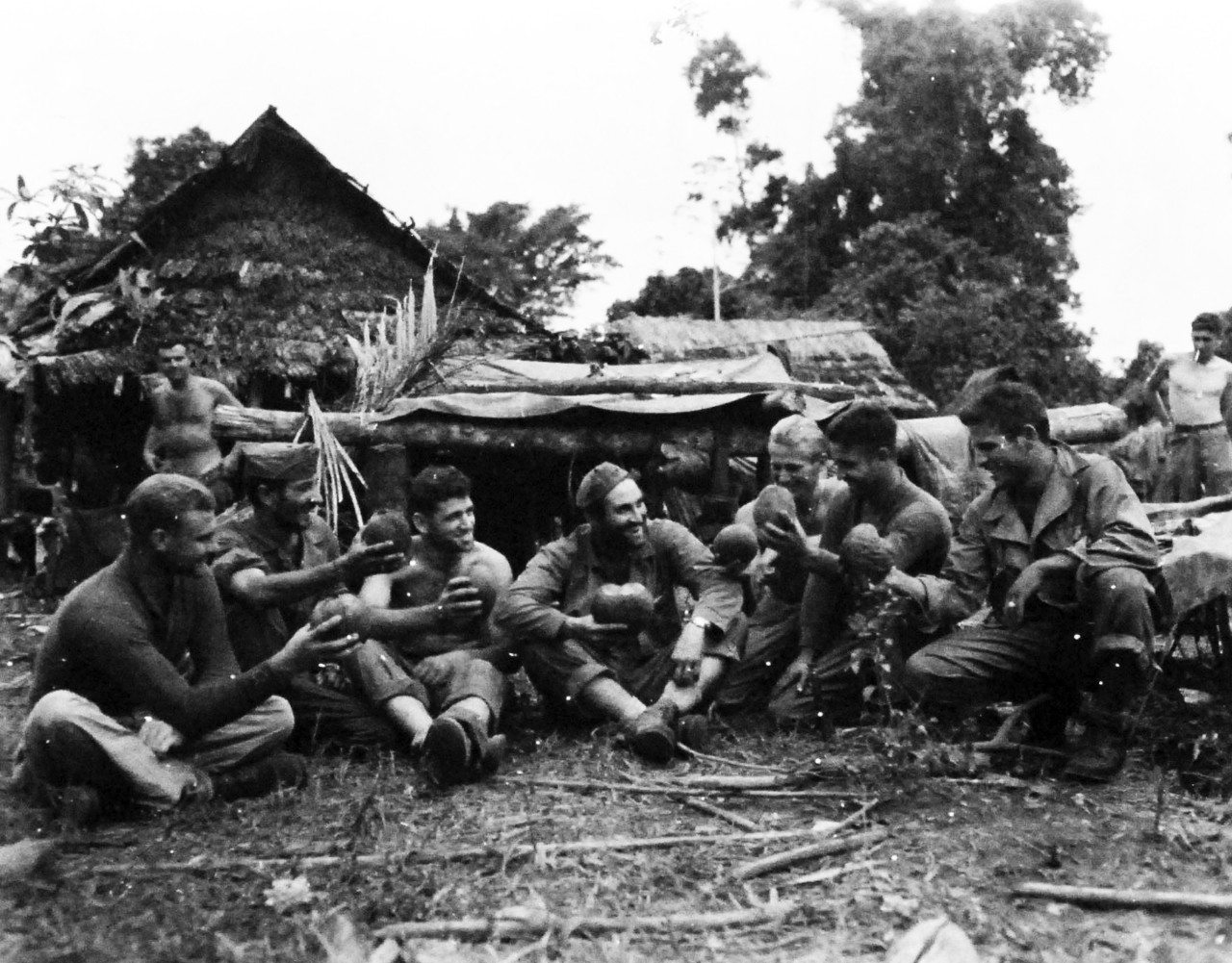 127-GW-966-77431:  Battle of Cape Gloucester, New Britain, December 1943-January 1944 “Birthday Toast”.   A toast if drunk in coconut juice on the occasion of the 24th birthday of Sergeant Milan A. Cicak, USMC.  The birthday found him and his buddies on a patrol in the Cape Glouchester jungle.  That’s Cicak in the center.  Left to right:  Gunnery Sergeant William E. Eisenhower; Private First Class Dominik D. Garogano.   Official U.S. Marine Corps Photograph, now in the collections of the National Archives.   (2014/7/9).