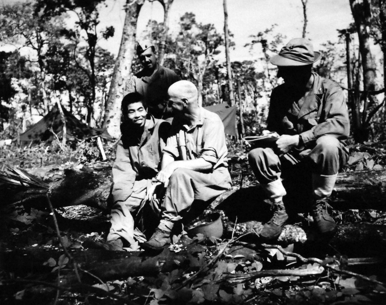 127-GW-971-76795:   Battle of Cape Gloucester, New Britain, December 1943-January 1944.   Standing is MP Corp, Edwin Yarbrough.  Sitting (left to right):  Japanese prisoner Major Sherwood F. Moran (interpreter), talks with Japanese prisoner captured on Cape Gloucester, who happens to be from the same locality as Major Moran who spent twenty years in Japan before the war.    Photographed by Sergeant R.M. Howard, USMCR, 20 January 1944.  Official U.S. Marine Corps Photograph, now in the collections of the National Archives.   (2014/7/9).