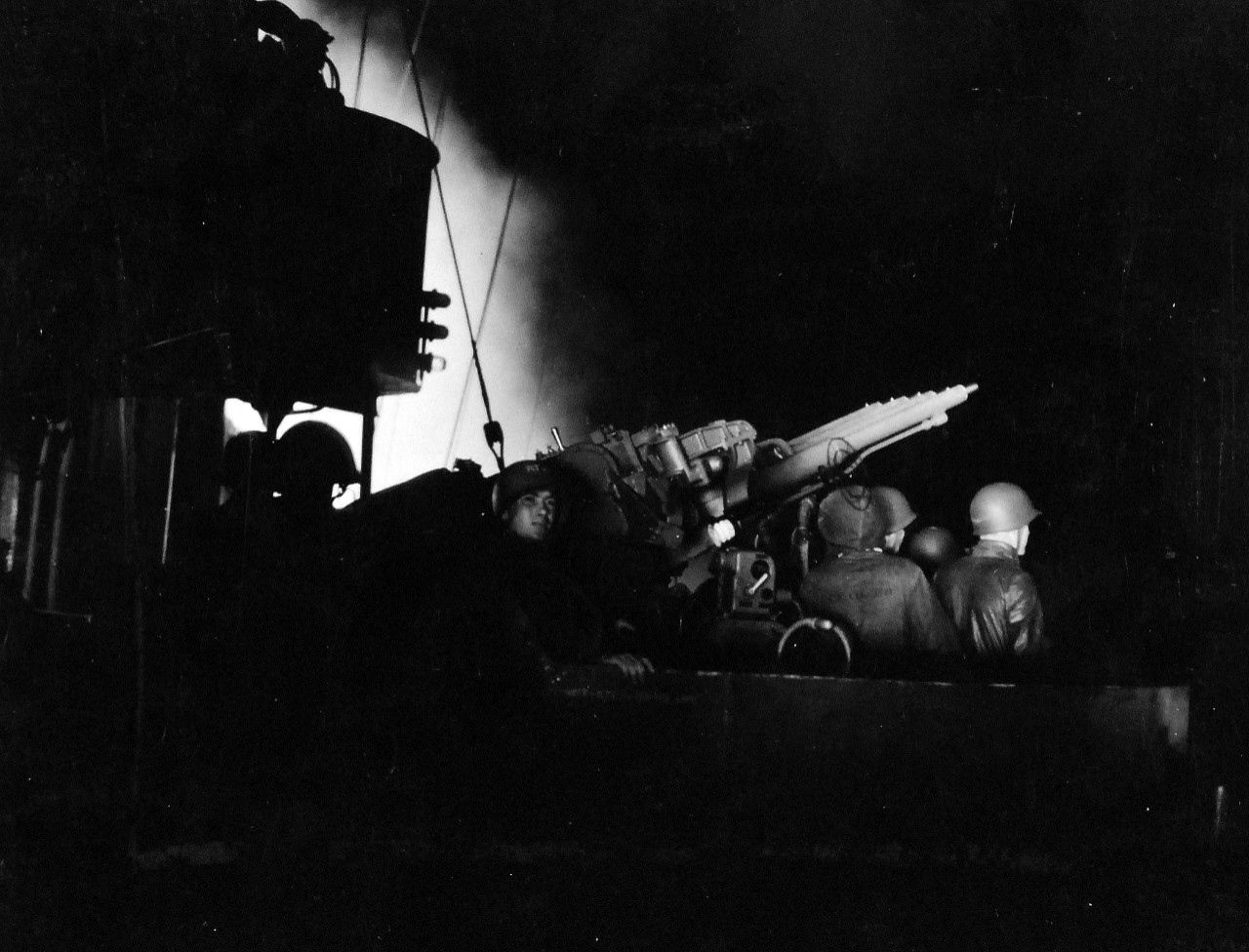 80-G-54554:  Battle of Kula Gulf, July 5-6, 1943.   Aboard USS Honolulu (CL- 48).  Shown is the night gunnery by the 1.1 gun crew on superstructure lit by gunfire.    Photograph, July 1943.   Official U.S. Navy photograph, now in the collections of the National Archives.   (2016/07/19).