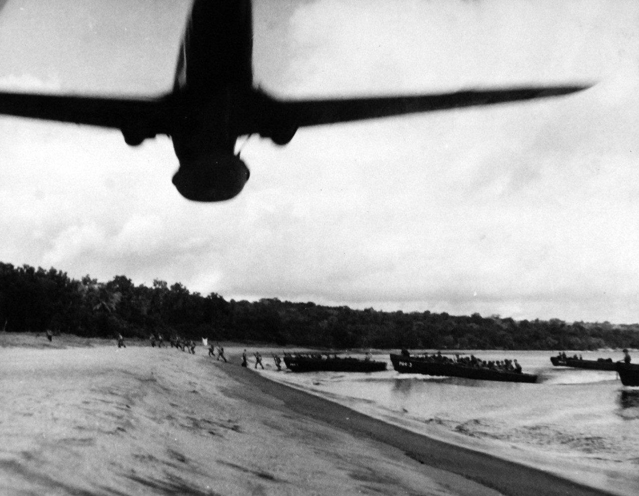 80-G-52671:   Rendova Island Invasion, June 30, 1943.  Landing craft debouch U.S. amphibious troops who run for the trees.   Overhead a USAAF P-40 provides air coverage.   Official U.S. Navy Photograph, now in the collections of the National Archives.  (2018/04/04). 