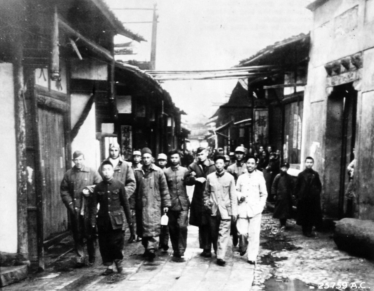 111-SC-A-25759AC-1:   Doolittle Raid on Japan, April 18, 1942.  Chinese soldiers bring in a group of General Doolittle’s Tokyo Raiders to the tiny village near where their bomber crashed.  Center right, his arm held by a Chinese, is Colonel John Hilger, who was injured, April 21.    U.S. Army photograph, now in the collections of the National Archives.  (2017/05/02).