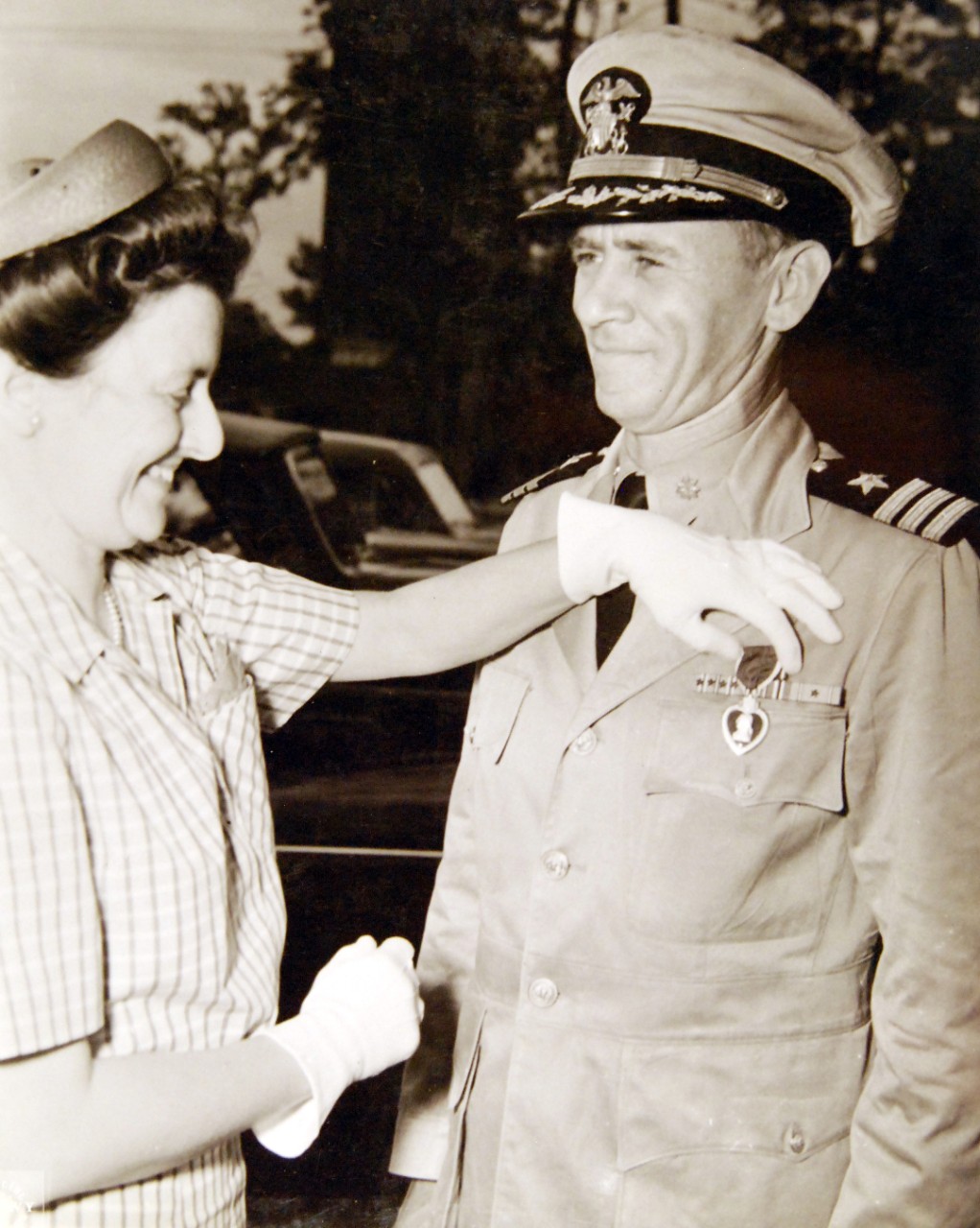 80-G-42770:  Commander E. J. Davis, USN, Purple Heart.      Commander Davis, fomer gunnery officer of USS Yorktown (CV-5), at Naval Operating Base, Norfolk, Virginia,  receives the Purple Heart Medal for the injuries received in the Battle of Midway.  Shown:   Mrs. E. J. Davis pins medal on husband, as Commander R.G. Pennoyer, Commanding Officer of Fleet Service Schools looks on.   Photograph released July 10, 1943.  Official U.S. Navy Photograph, now in the collections of the National Archives.   (2017/08/01).  