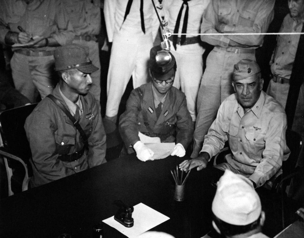 80-G-490485:   Surrender of Wake Island, September 3, 1945.     Discussing the terms of surrender on board USS Levy (DE-162).  Shown left to right:  Rear Admiral Shigematsu Sakaibara, Lieutenant P.H. Nakacato and Brigadier General Lawson Sanderson, USMC.   Photograph released on 4 September 1945.  U.S. Navy photograph, now in the collections of the National Archives.    (2014/5/29).