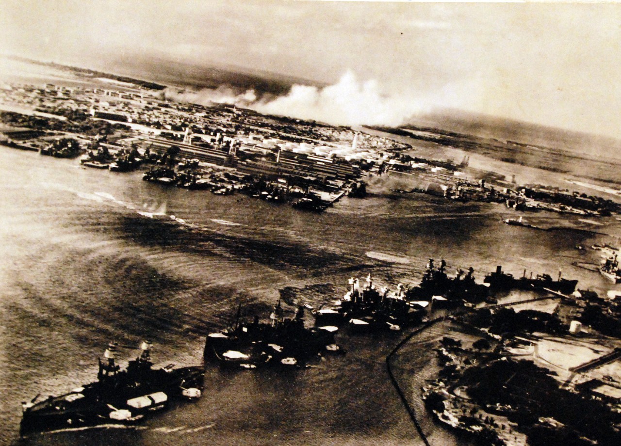 <p>80-G-30550: Pearl Harbor Attack, 7 December 1941. Torpedo planes attack &quot;Battleship Row&quot; at about 0800 on 7 December, seen from a Japanese aircraft. Ships are, from lower left to right: Nevada (BB-36) with flag raised at stern; Arizona (BB-39) with Vestal (AR-4) outboard; Tennessee (BB-43) with West Virginia (BB-48) outboard; Maryland (BB-46) with Oklahoma (BB-37) outboard; Neosho (AO-23) and California (BB-44). West Virginia, Oklahoma and California have been torpedoed, as marked by ripples and spreading oil, and the first two are listing to port. Torpedo drop splashes and running tracks are visible at left and center. White smoke in the distance is from Hickam Field. Grey smoke in the center middle distance is from the torpedoed USS Helena (CL-50), at the Navy Yard's 1010 dock. Japanese writing in lower right states that the image was reproduced by authorization of the Navy Ministry. Also at NHHC as NH 50931. National Archives caption – from Japanese, “Our Sea Eagles’ determined attack had already opened, and a column of water from a direct torpedo hit on a Maryland Class is rising. On the surface of the water concentric waves are traced by the direct torpedo hits, while murky crude oil flows out. The three bright white streaks between the waves are the torpedo tracks. In the distance, the conflagration at the Hickman Airfield Hangars is seen.” (9/22/2015).</p>
