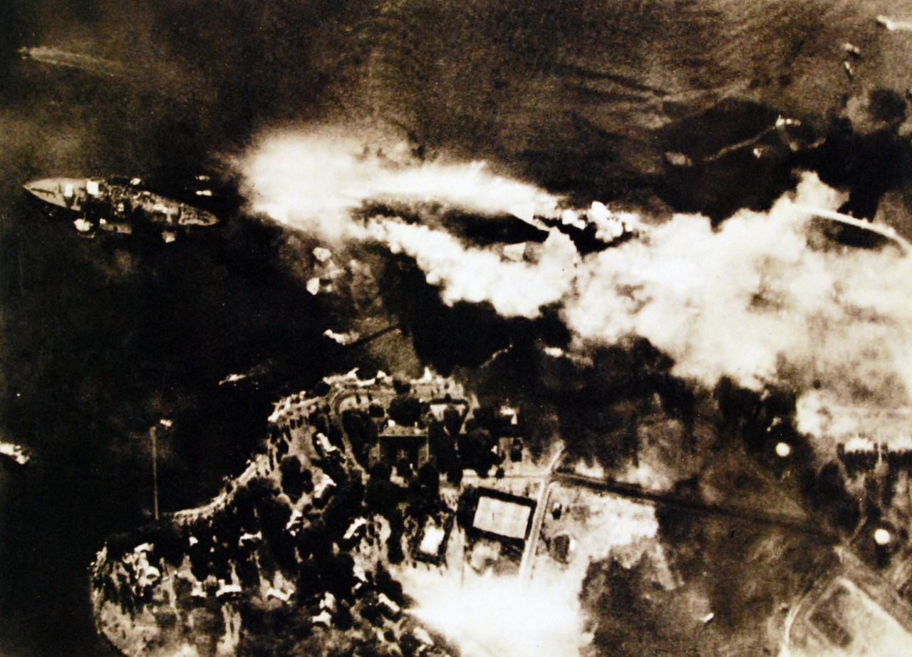 <p>80-G-30552: Pearl Harbor Attack, 7 December 1941. Vertical aerial view of &quot;Battleship Row&quot;, beside Ford Island, soon after USS Arizona was hit by bombs and her forward magazines exploded. Photographed from a Japanese aircraft. Ships seen are (from left to right): USS Nevada; USS Arizona (burning intensely) with USS Vestal moored outboard; USS Tennessee with USS West Virginia moored outboard; and USS Maryland with USS Oklahoma capsized alongside. Smoke from bomb hits on Vestal and West Virginia is also visible. Japanese inscription in lower left states that the photograph has been reproduced under Navy Ministry authorization. Also at NHHC as NH 30552. Translated Japanese caption reads, “Capsizing, Sinking, Burning, the anchorage of the American capital ships is changed to a scene of carnage. In rapid succession, the enemy war vessels were set ablaze by the violent bombing attacks which followed the torpedo attacks. The special service ship in the capital ship anchorage has already been sunk. The violent smoke from the exploding powder magazine is rising from a vessel of the Oklahoma class alongside. A Pennsylvania class ship, capsized and sinking, shows its bottom. Two ships the California class and the Maryland class are in flames from direct bomb hits. In the upper right-hand part of the photograph are what appear to be several rescue ships, darting right and left. (9/22/2015).</p>

