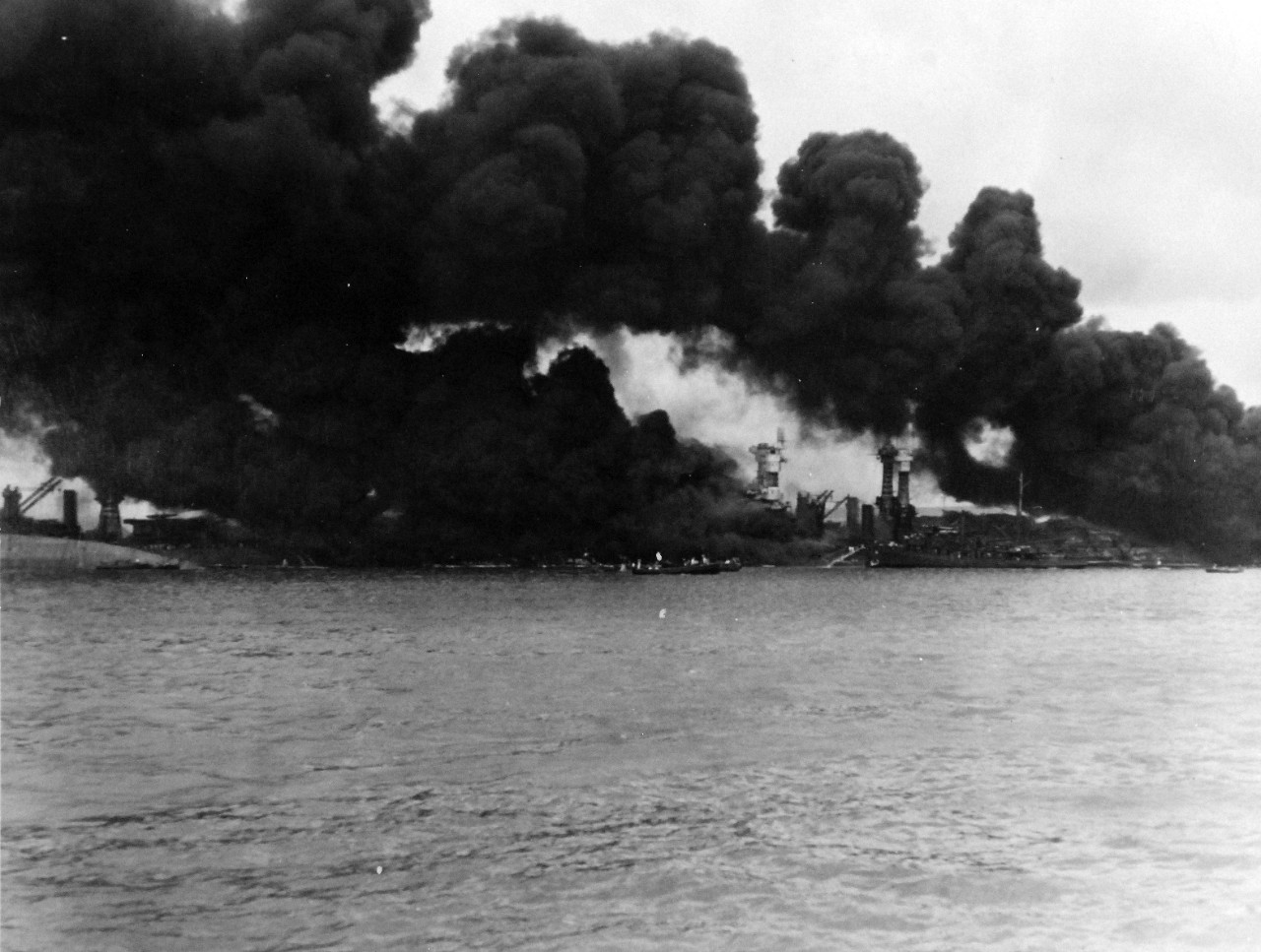80-G-32416:  Japanese Attack on Pearl Harbor, December 7, 1941.  View of “Battleship Row” during or immediately after the Japanese raid.  USS West Virginia (BB 48) and USS Tennessee (BB 43) are in the center right.   The capsized USS Oklahoma (BB 37) is at the left, alongside USS Maryland (BB 46). Official U.S. Navy photograph, now in the collections of the National Archives.    (9/15/15).