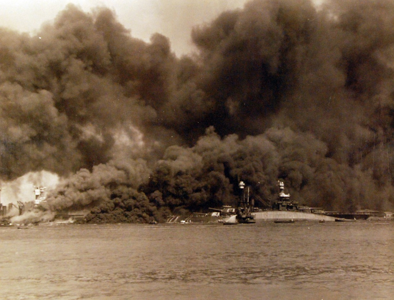 <p>80-G-32417: Japanese Attack on Pearl Harbor, December 7, 1941. View of “Battleship Row” during or immediately after the Japanese raid. The capsized USS Oklahoma (BB 37) is in the center, alongside USS Maryland (BB 46). Note, on the mount card, hand-writing reads, “Negative reversed in formatting.”&nbsp;</p>
