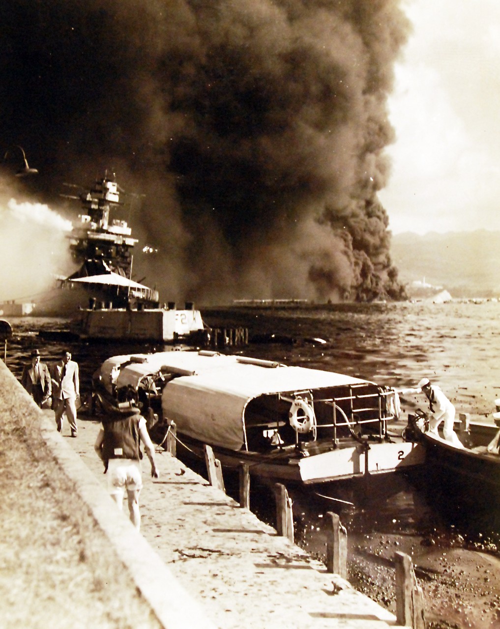 80-G-32947:   Japanese Attack on Pearl Harbor Attack, 7 December 1941.    Burning and damaged ships at Pearl Harbor after the Japanese attack.   Shown is USS California (BB 44), foreground, burning at Naval Air Station Ford Island.   USS Oklahoma (BB 37) is shown capsized in the background.  U.S. Navy photograph, now in the collections of the National Archives.   (9/13/2013).