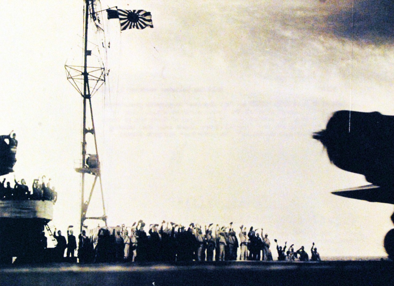 80-G-30549:   Pearl Harbor Attack, 7 December 1941.  A Japanese Navy Type 97 Carrier Attack Plane ("Kate") takes off from a carrier as the second wave attack is launched. Ship's crewmen are cheering "Banzai"   This ship is either Zuikaku or Shokaku.  Note light tripod mast at the rear of the carrier's island, with Japanese naval ensign.  Also at NHHC as NH 50603.   National Archives photograph has a Japanese caption (translated) , “The moment at which the Hawaii surprise attack force is about to take off from the carrier…On the faces of those who go forth to conquer and those who send them off there floats only that beautiful smile which transcends death.” (9/22/2015).