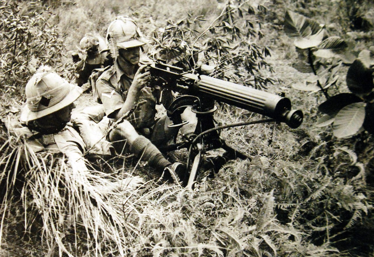 Malayan Campaign, December 1941-January 1942.  The Manchesters in the Far East.  Members of the Manchester Regiment in the Far East is busily engaged in preparing for anything the future may have in store and the art of camouflage is not being overlooked.   Shown: A Vickers gun in use during an exercise.  Office War Information Photograph. Courtesy of the Library of Congress. (2016/01/22).
