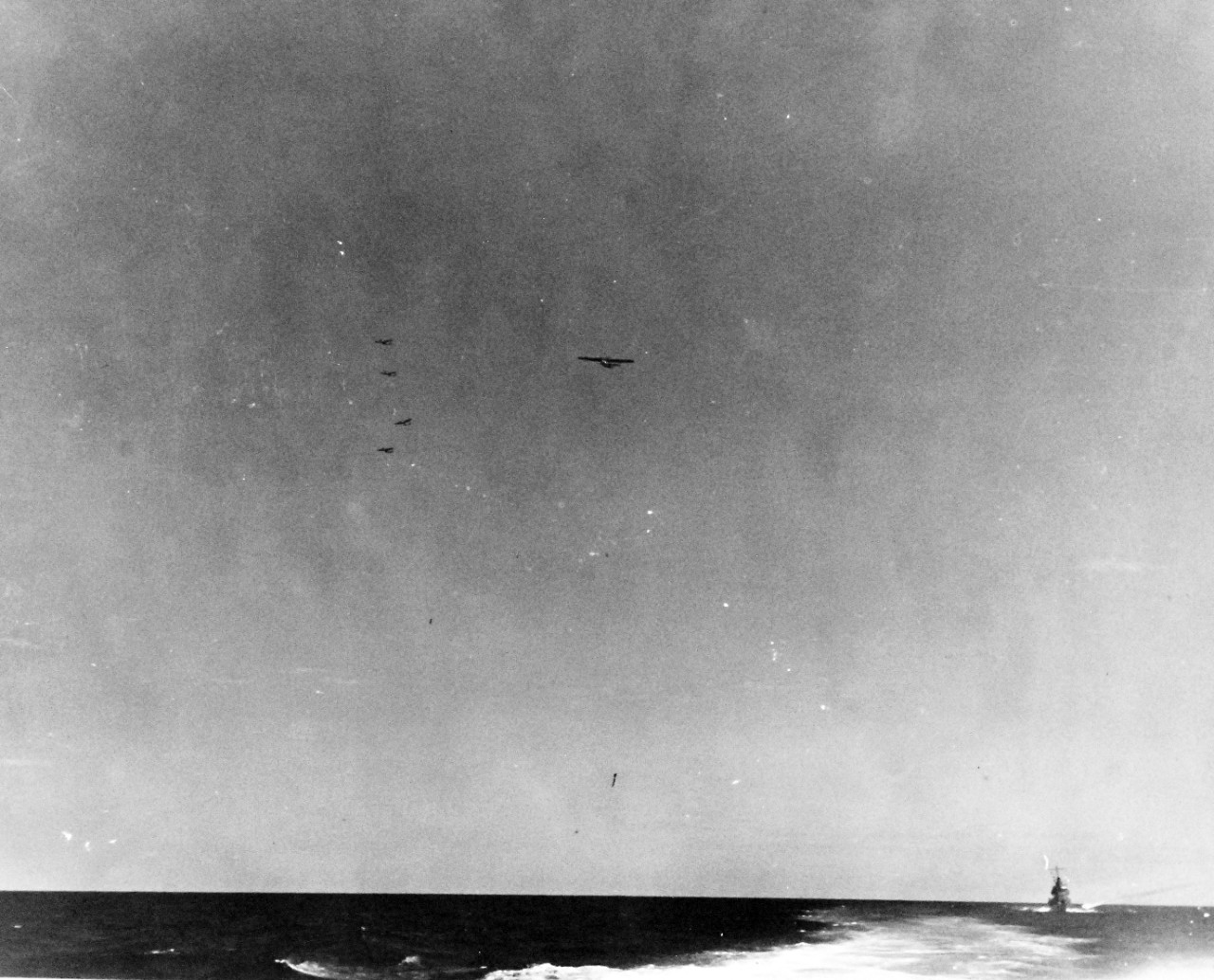 80-G-299831:  Battle of the Eastern Solomons, 24 August 1942.   A patrol plane from USS Enterprise (CV 6) escorted by 4 fighters of Combat Air Patrol flying directly through the formation of attacking Japanese planes.  As seen from USS Portland (CA 33).      Official U.S. Navy Photograph, now in the collections of the National Archives.  (2016/07/05).