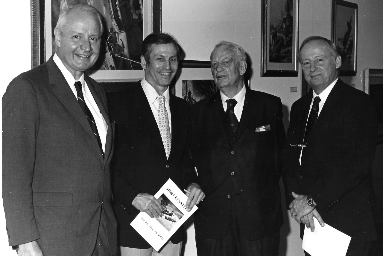 NMUSN-88:  Admiral Arleigh A. Burke, USN, (Retired), 1982.   Admiral Arleigh A. Burke (center right), artist Mort Kunstler (center left), and two unidentified attendees at the Navy Memorial Museum (now National Museum of the U.S. Navy) during the opening of the Mort Kunstler Art Exhibit:  The Proudest Moments of Old Glory.    National Museum of the U.S. Navy Photograph Collection.  