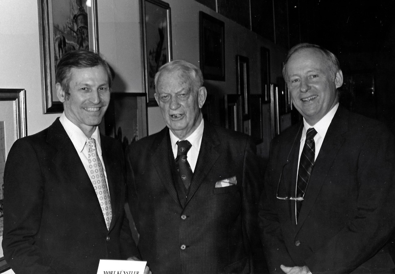 NMUSN-87:  Admiral Arleigh A. Burke, USN, (Retired), 1982.    Admiral Arleigh A. Burke (center),  artist Mort Kunstler (left), and an unidentified attendee at the Navy Memorial Museum (now National Museum of the U.S. Navy) during the opening of the Mort Kunstler Art Exhibit:  The Proudest Moments of Old Glory.    National Museum of the U.S. Navy Photograph Collection.  