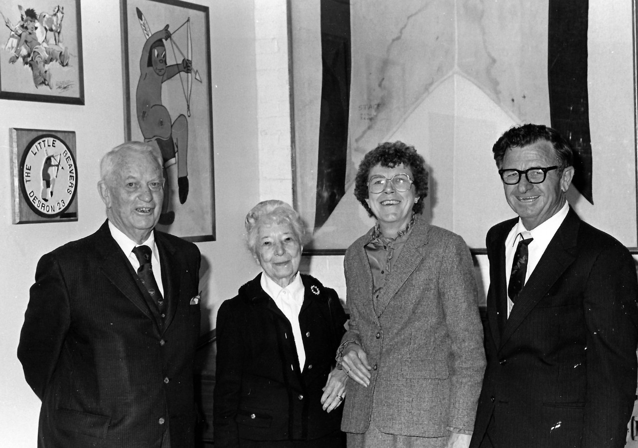 NMUSN-86:  Admiral Arleigh A. Burke, USN, (Retired), and Wife, 1982.    Admiral Arleigh A. Burke and wife (left) are photographed with two visitors at the Navy Memorial Museum (now National Museum of the U.S. Navy) during the opening of the Mort Kunstler Art Exhibit:  The Proudest Moments of Old Glory.    National Museum of the U.S. Navy Photograph Collection.  