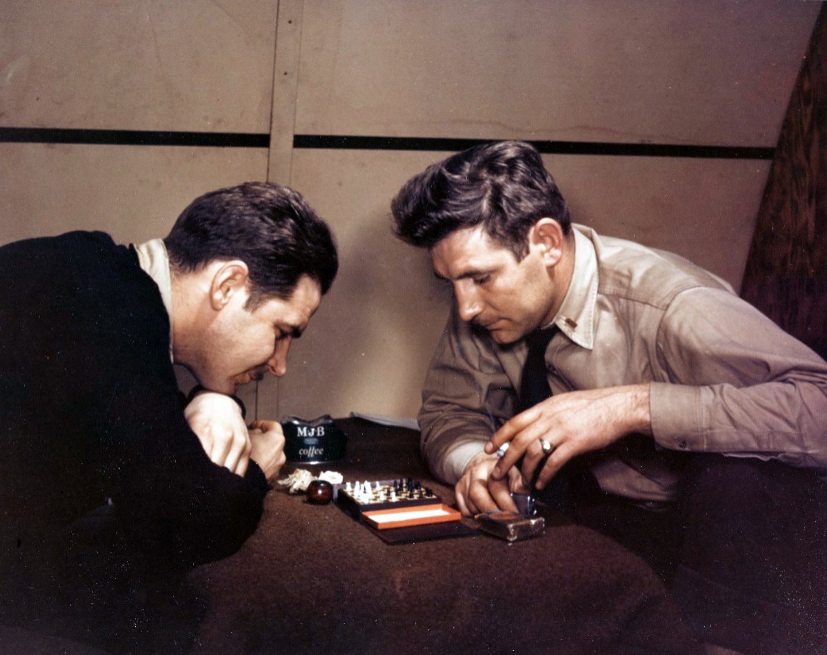 Chess Game. A chess game occupies the time of two Navy pilots in their quarters at an Aleutian Advanced base, circa 1942-43. Not the pack of “Lucky Strike” cigarettes and coffee can astray. Photographed by Horace Bristol. Official U.S. Navy Photo...