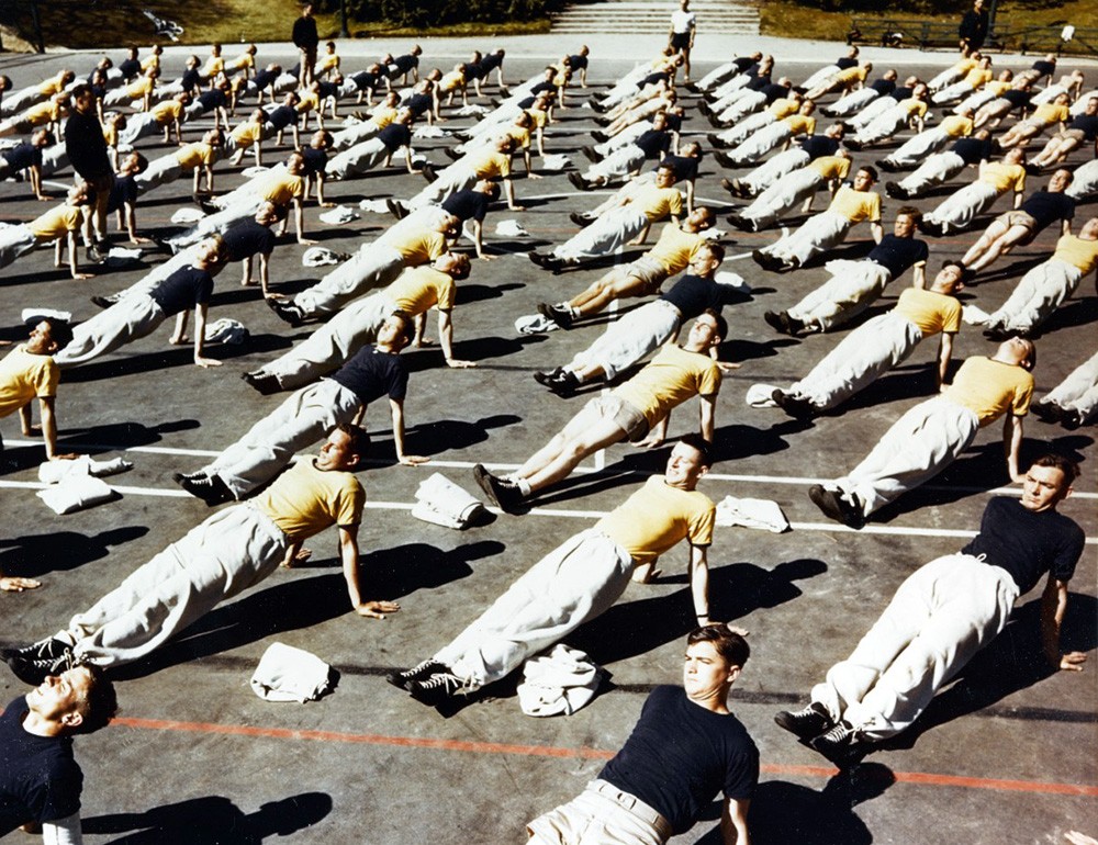 Del Monte Pre-Flight School, Monterey, California, 1942-44. Naval Aviation Cadets do calisthenics in the tennis court of the school, which was located at the former Del Monte Hotel. Official U.S. Navy Photograph, now in the collections of the Nat...