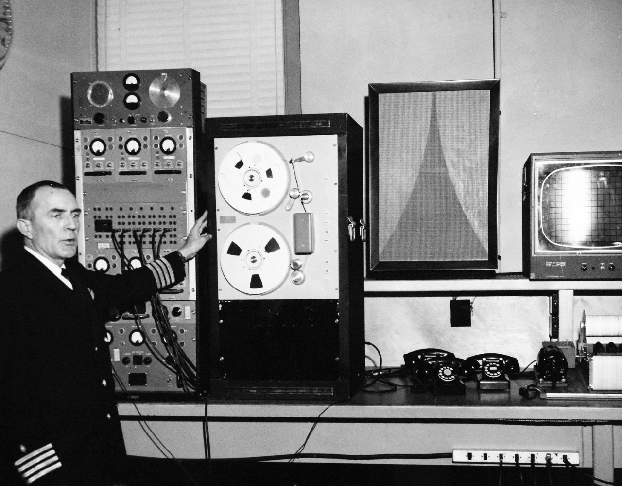 330-PS-8850-1:  U.S. Navy Conducts Physical Study By Telephone.  Captain Norman Les Barr, MC, USN, explains the functions of the equipment used in transmitting physiological information, March 21, 1958.  Official Department of Defense photograph, now in the collection of the National Archives.   