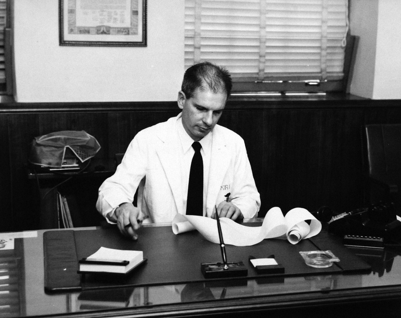 330-PS-8850-3:  U.S. Navy Conducts Physical Studies By Telephone.  Captain Jack P. Pollard, MC, USN, examines permanent record of physiological information transmitted over telephone circuit, March 21, 1958.  Official Department of Defense photograph, now in the collection of the National Archives.   