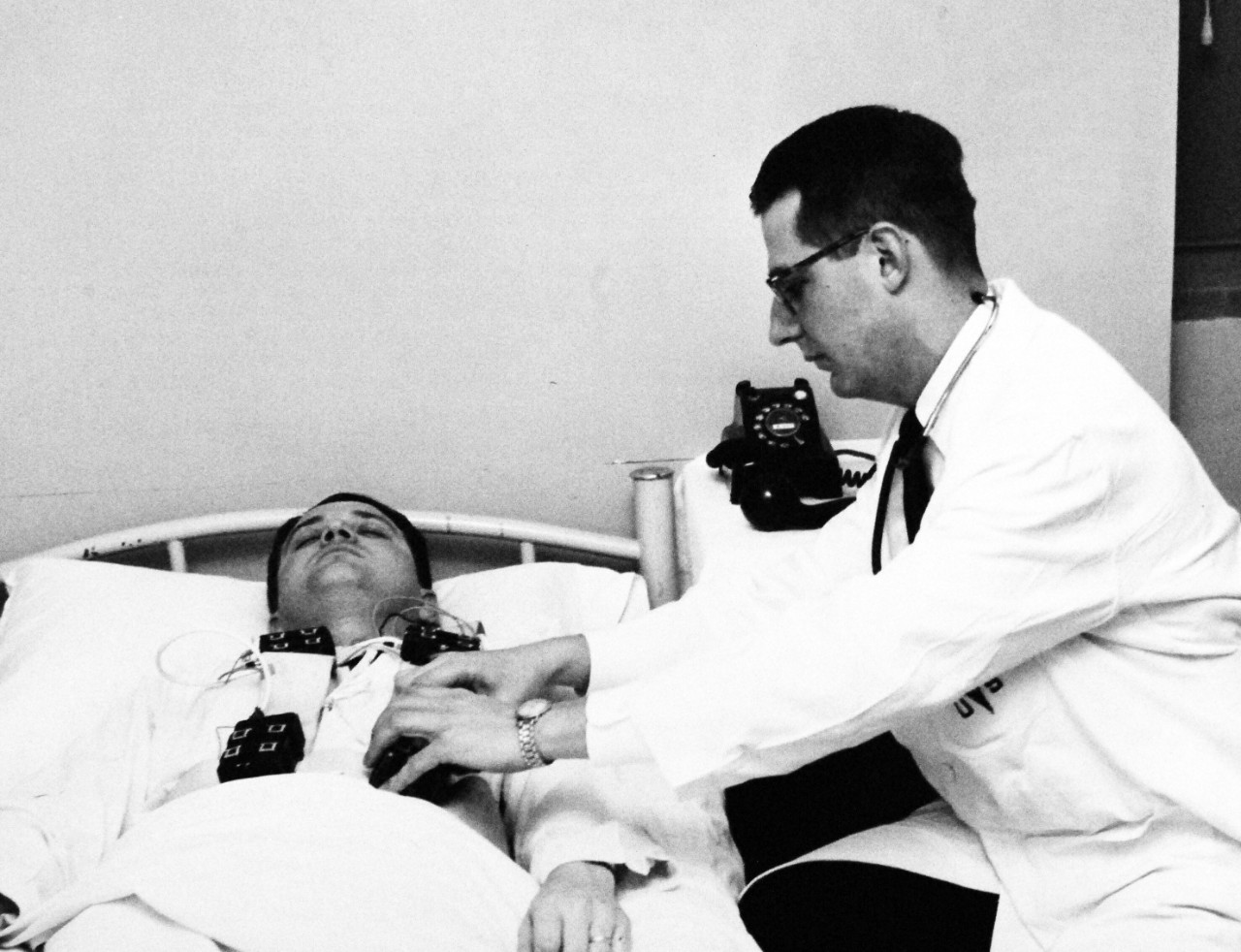 330-PS-8850-5:  U.S. Navy Conducts Physical Studies By Telephone.  Lieutenant N. R. Stanport, MC, USN, attaching electrode and power supply to patient, March 21, 1958.  Official Department of Defense photograph, now in the collection of the National Archives.   