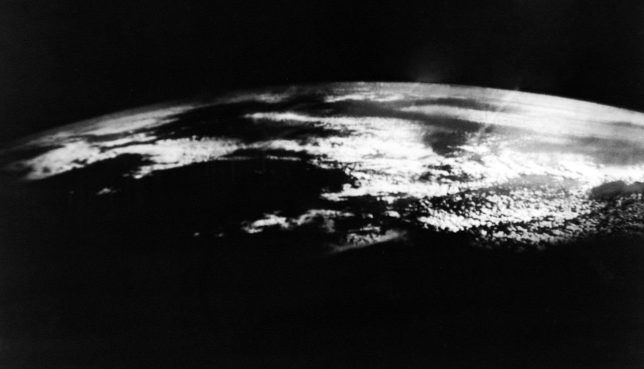 USN 710339:   First Picture from Navy Weather Surveillance Rocket Camera, December 1958.   Tests of a new U.S. Navy Rocket Camera Unit designed specifically to photograph high-altitude ocean cloud formations associated with hurricane and weather frontal systems are being conducted by the Office of U.S. Naval Research.  The rocket-camera unit will be utilized where there are no permanent weather stations.  These are the first pictures which have been obtained from Project Hugo (High Unusual Geophysical Operations) rocket which soared to an altitude of 86.25 miles during the first test flight on December 5, 1958.  In this picture, a composite of five photographs, a frontal cloud formation is shown over the Atlantic Ocean starting about 200 miles off shore and stretching nearly 700 miles further seaward.  This mosaic strip covers approximately 1000 miles in further inward ranging approximately from the southern tip of Maine to mid-Florida.  The film was successfully recovered at sea from the nose cone of the Nike-Cajun Rocket by USS Leary (DD 879).   The rocket was fired from the National Aeronautics and Space Agency’s pilotless aircraft and research station at Wallows Island, Virginia.   Official U.S. Navy Photograph, now in the collections of the National Archives.   