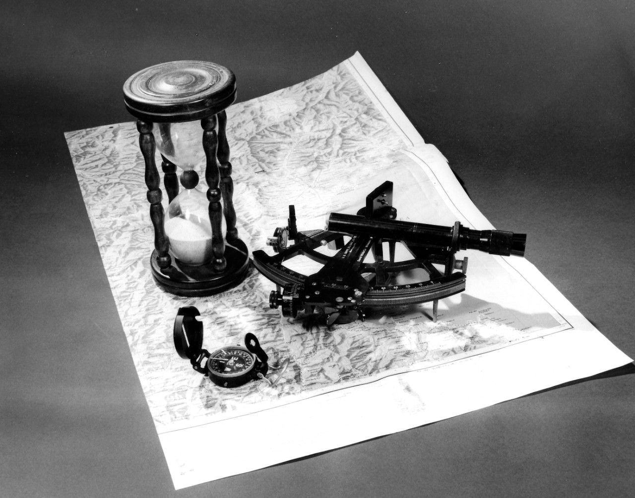 NMUSN-3105: Navigation Exhibit, 1980s. An hourglass, sextant, compass, and map are shown. National Museum of the U.S. Navy Photograph Collection.