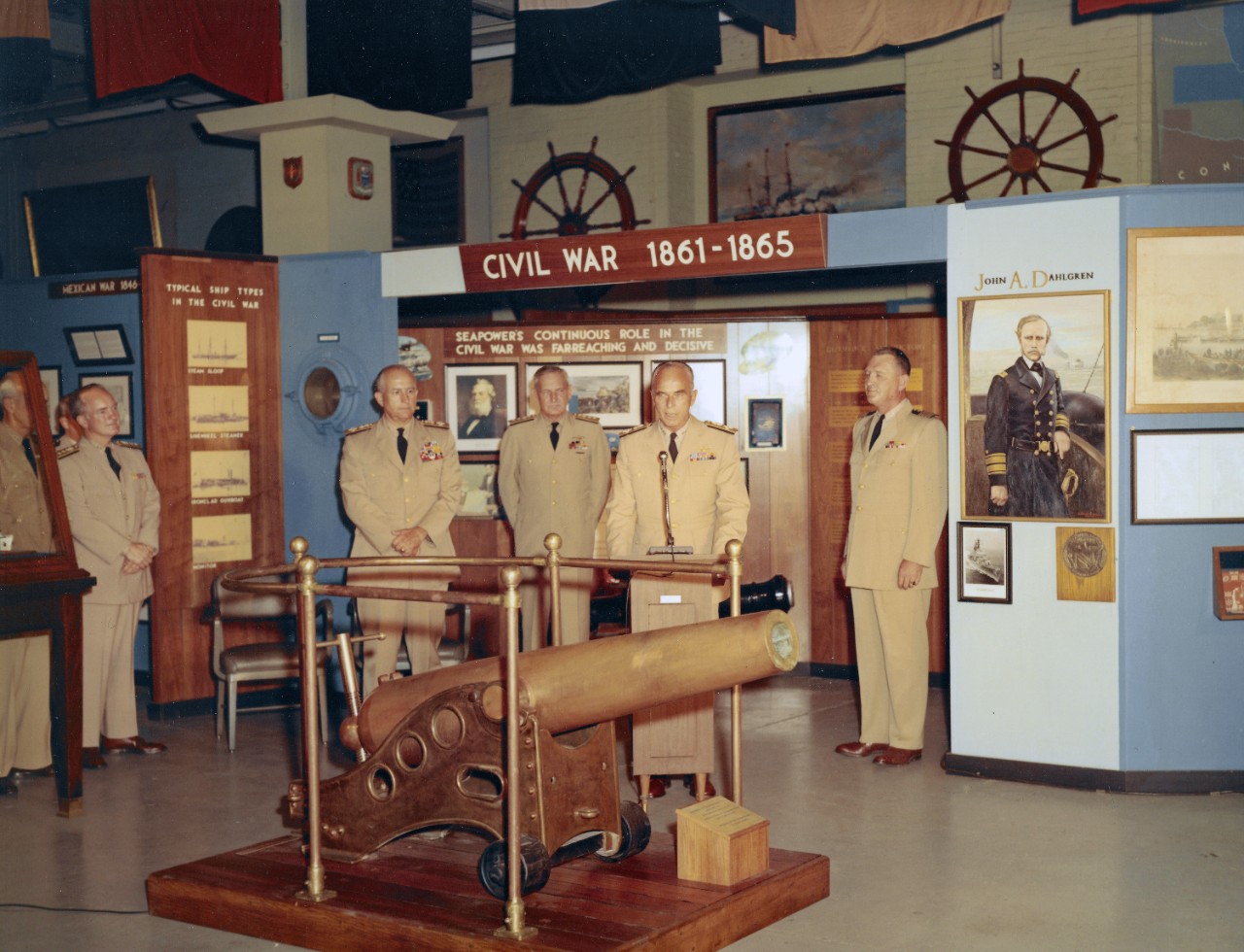 NMUSN-27:    Presentation of 20-Pounder Dahlgren Gun, Navy Memorial Museum, July 1968.    Admiral Willard J. Smith, Commandant, U.S. Coast Guard presents the gun in a formal ceremony.   Others in attendance.   Shown, left to right:   Rear Admiral Ernest M. Eller (blocked by exhibit case); Rear Admiral R.W. Goehring; Admiral Thomas H. Moorer, Chief of Naval Operations; Rear Admiral Elliott Loughlin; Admiral Willard J. Smith, Commandant, U.S. Coast Guard (speaking); and Captain Roy C. Smith, Director, Navy Memorial Museum.    This artifact is now on display by the frigate, USS Constitution, Fighting Top Area.    National Museum of the U.S. Navy Photograph Collection.   