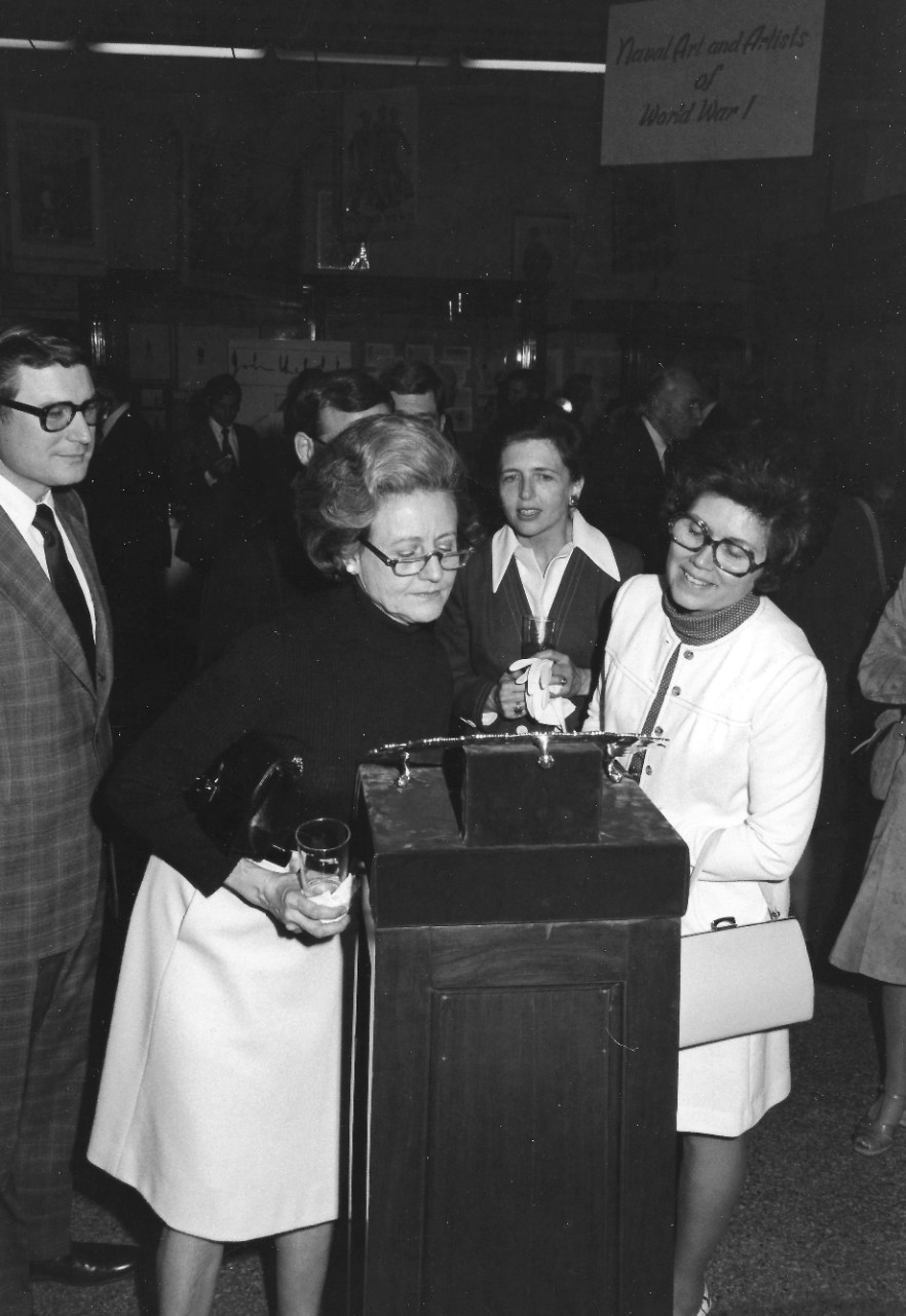 NMUSN-136:   Presentation of HMS Intrepid Silver Tray, April 1975.     Shown:  Attendees of the presentation look at the tray while at the Navy Memorial Museum, April 18, 1975.    National Museum of the U.S. Navy Photograph Collection.  