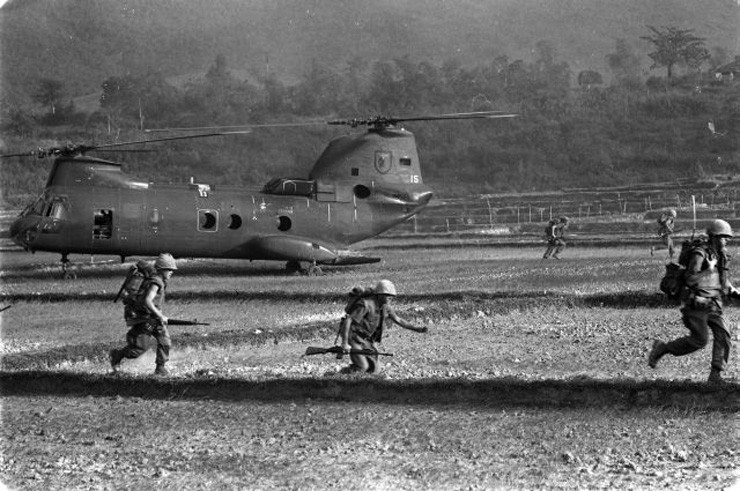 Photo of Marines sprinting across a rice paddy in South Vietnam after arriving at a landing zone on board CH-46 Sea Knight helicopters.