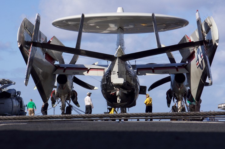 Photo showing an E-2 Hawkeye with its wings folded on board the carrier USS Carl Vinson