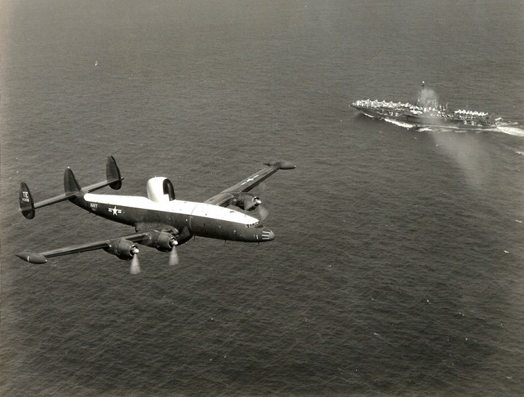 Photograph of a WV-2 Warning Star aircraft flying over the aircraft carrier USS Midway.