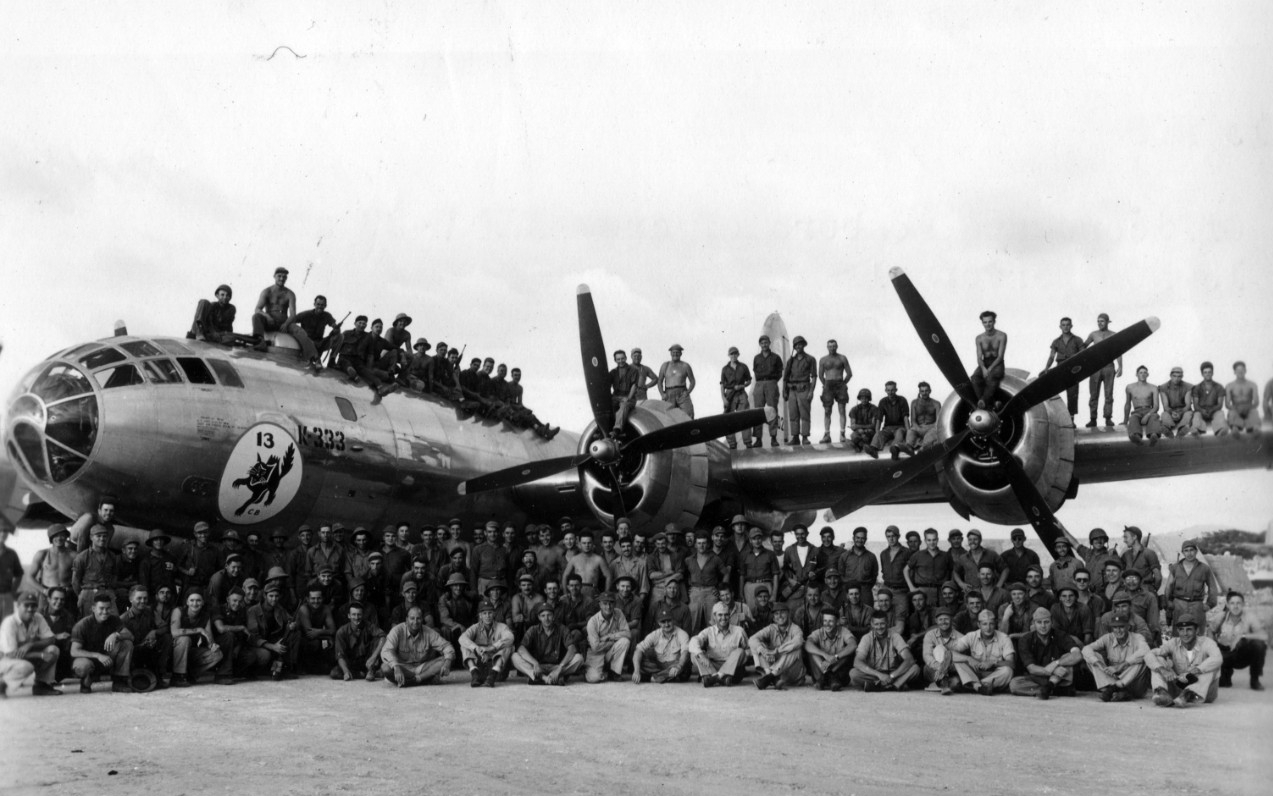 Officers and enlisted members of an Army Air Force B-29 and the 13th Naval Construction Battalion pose for a photograph on Tinian. 