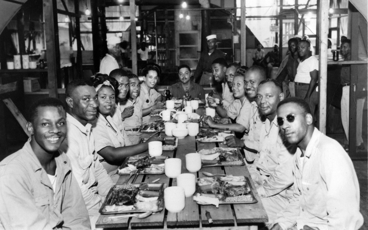 Members of the 34th Naval Construction Battalion host a luncheon for an African-American USO troop on Guadalcanal, Solomon Islands, pictured here in July 1944. 