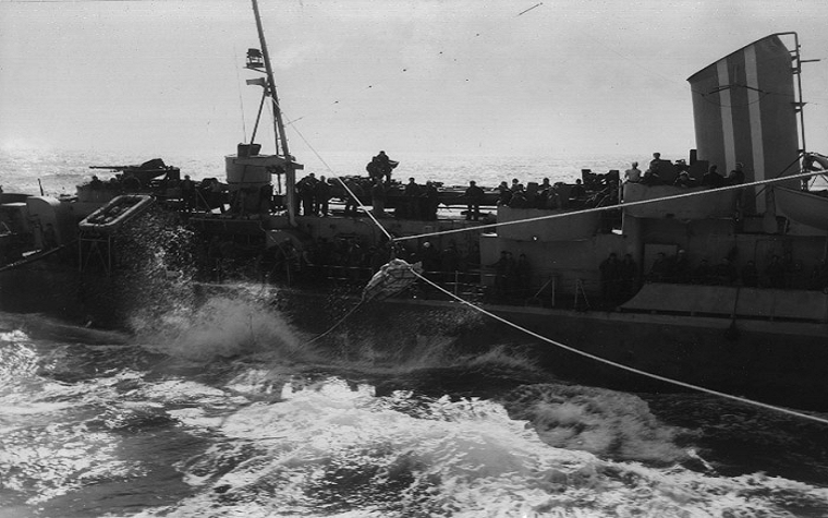 A survivor from the torpedoed Frederick C. Davis (DE-136) is transferred from Flaherty (DE-135) to Bogue (CVE-9), 24 April 1945. Photo taken from Bogue .