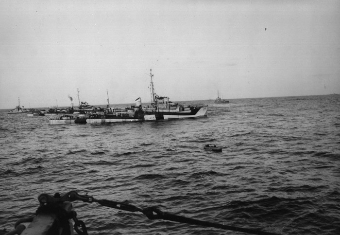 Surviving U-546 crewmembers in inflatable rafts floating among Second Barrier Force destroyer escorts, 24 April 1945.  