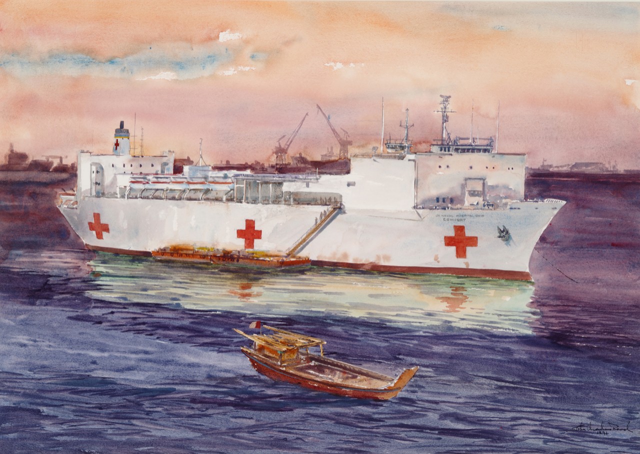 Hospital ship USS Comfort with a barge alongside, in the foreground is a small boat 
