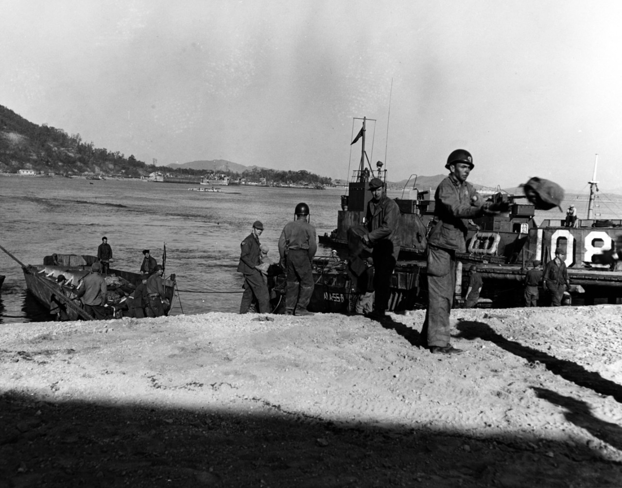 Troops unload landing craft at Inchon's Red Beach on 18 September 1950, three days after the initial landings there. The LCVP in the center is from USS Alshain (AKA-55). Wolmi-Do island is in the background.