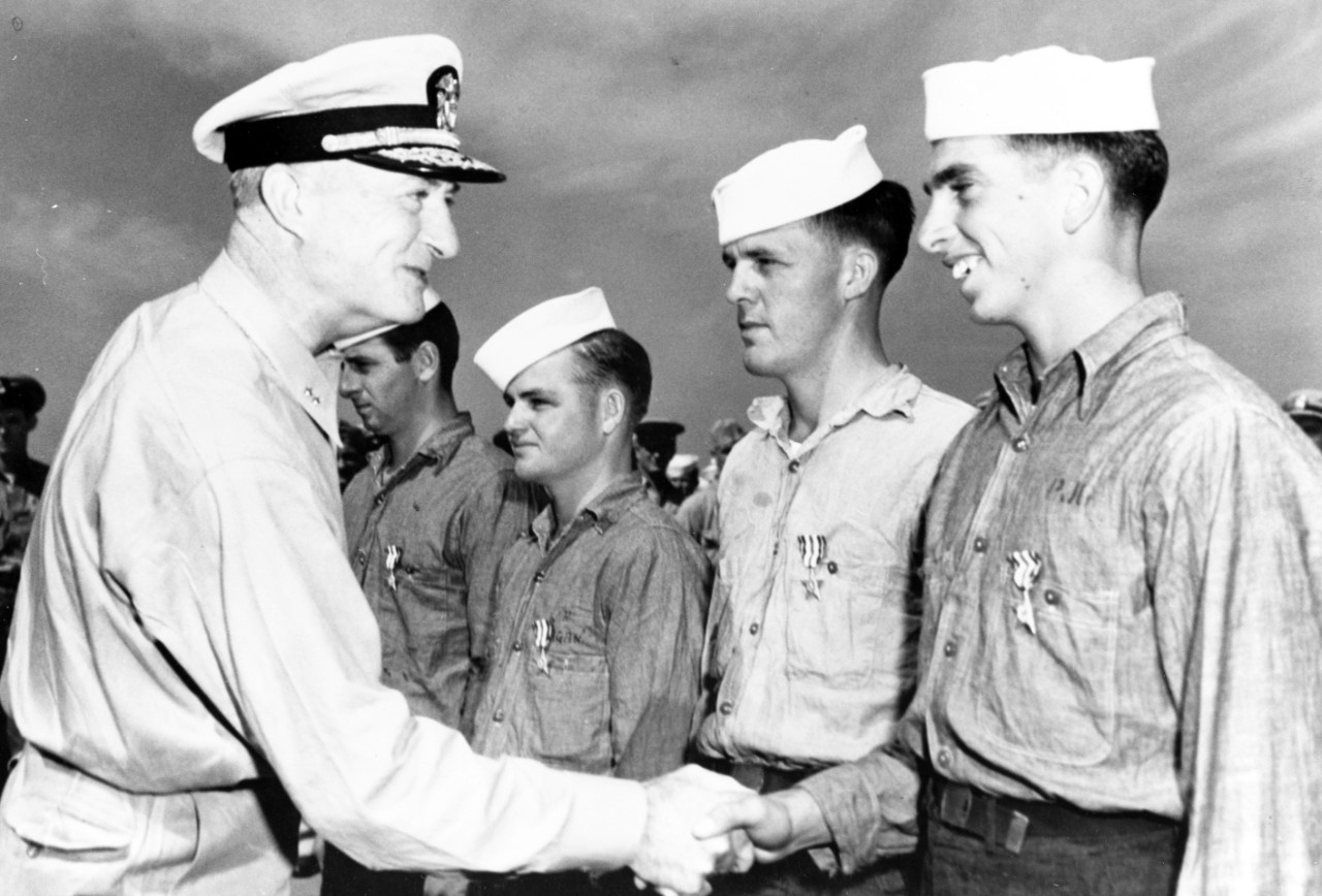 Rear Admiral James H. Doyle, USN, Commander, Task Force 90, congratulates four Sailors who have just received the Silver Star Medal for service as coxwains of LCVP landing craft during the Inchon Invasion. 